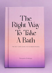 The Right Way To Take A Bath hardcover book with a soft touch matte pastel cover against a light purple background. The Right Way To Take A Bath is a self-care guide that captures bubble bath tips in a decor-friendly book that makes the perfect spa gift.