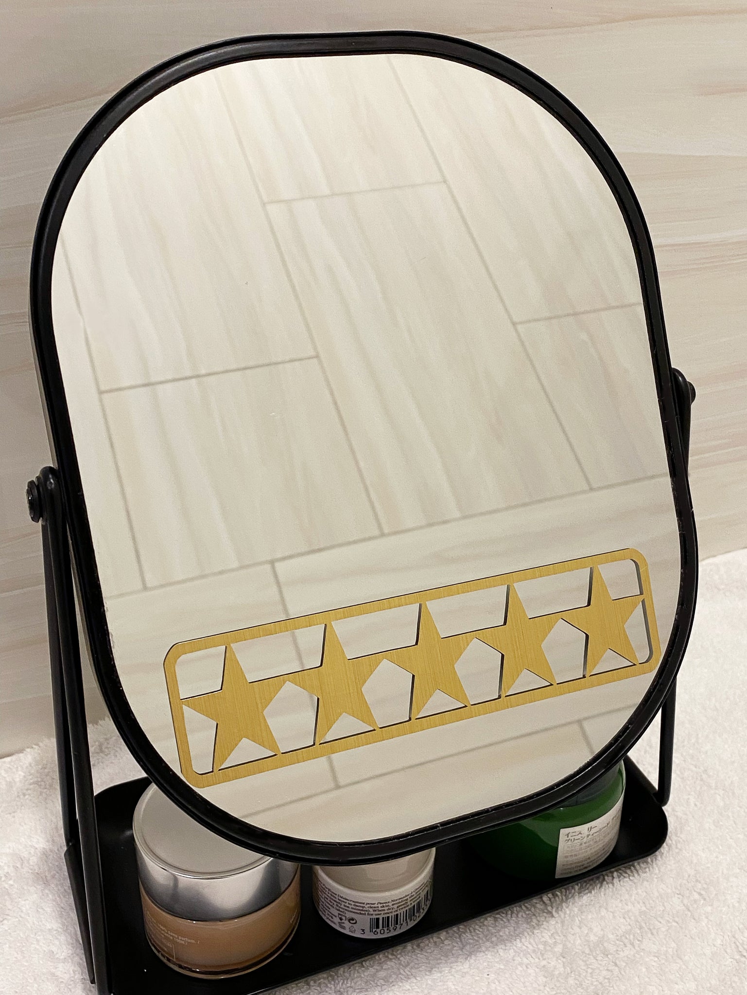 Gold 5 star mirror decal for daily positive affirmation. Mirror affirmation decal placed on modern black mirror for bathroom. Black mirror for bathroom has a tray for skincare products.