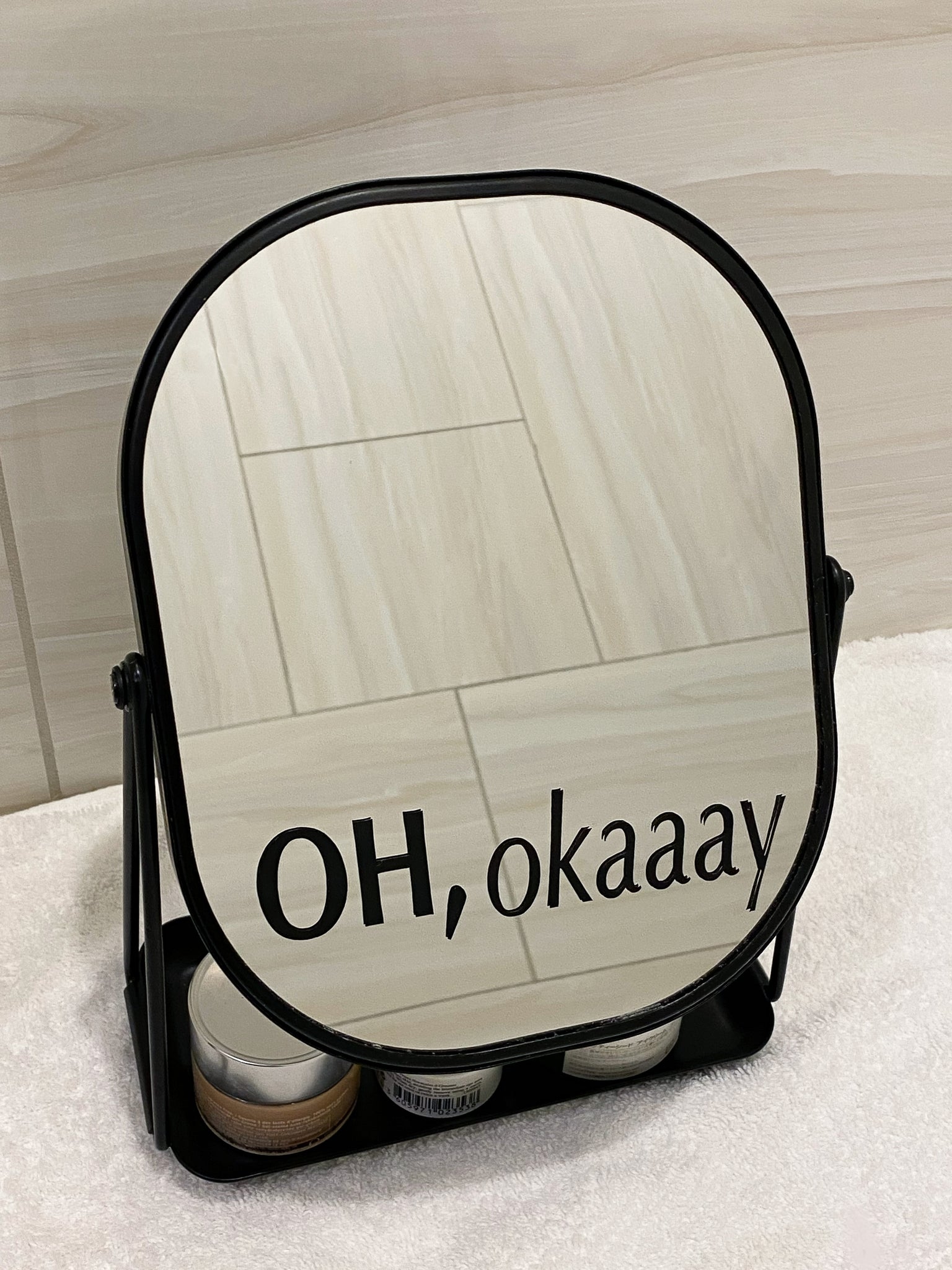 Black positive affirmation mirror decal for daily positive affirmation. Mirror affirmation decal placed on modern black mirror for bathroom. Black mirror for bathroom has a tray for skincare products. 